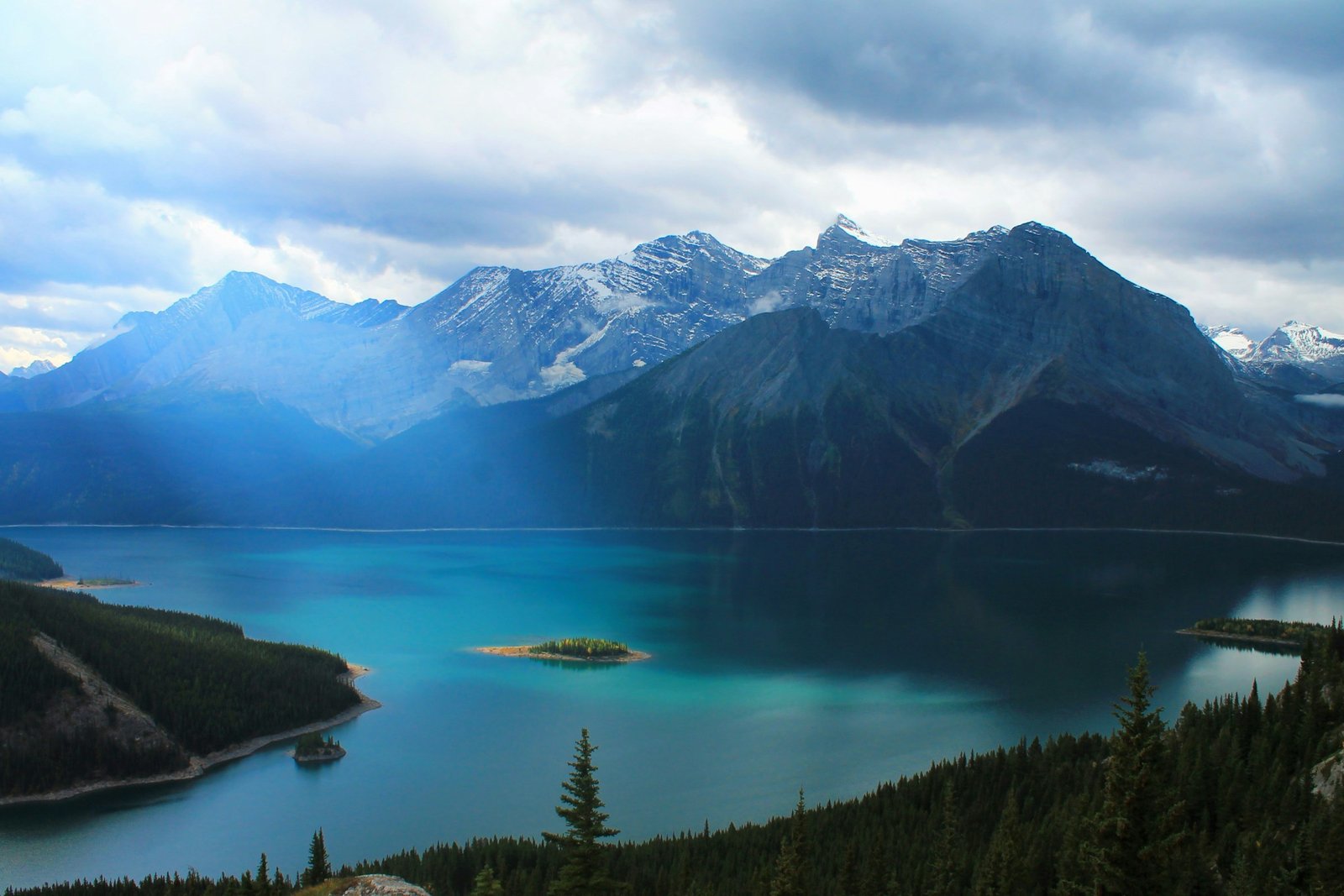 Turquoise lake and evergreen forest beneath the Canadian Rockies